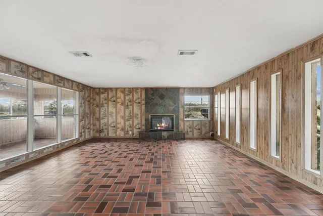 a view of a big room with windows and fireplace