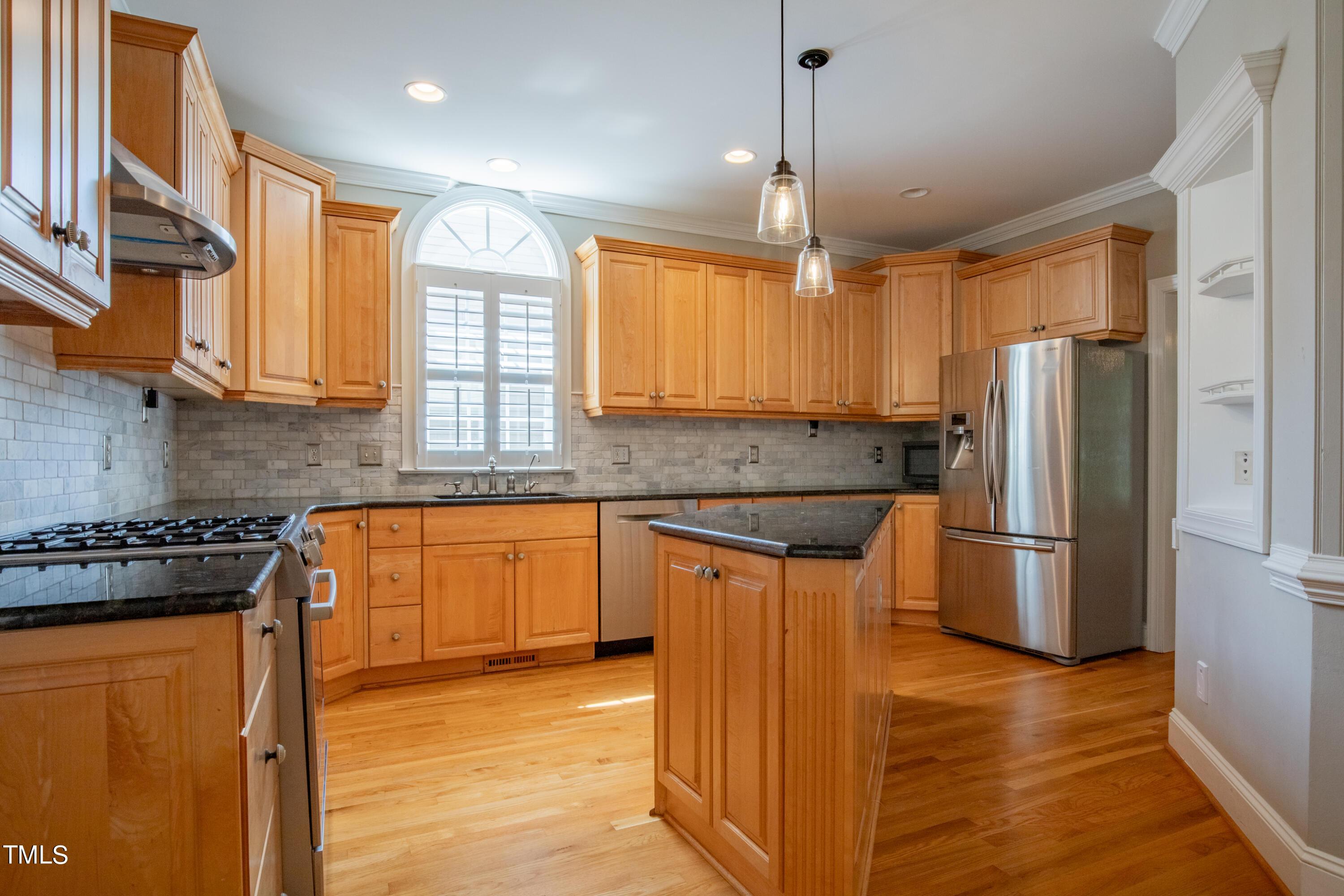 3308 Tall Tree Place Raleigh, NC 27607 - Photo 7 of 34 a kitchen with stainless steel appliances granite countertop a refrigerator a sink dishwasher a stove and a dining table with wooden floor