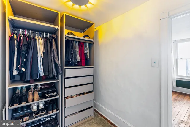 a hallway with front door wooden floor and a bathroom