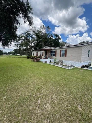 a view of a house with yard and sitting area