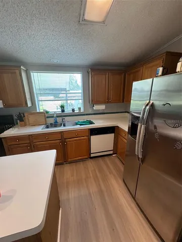 a kitchen with stainless steel appliances a sink a stove a refrigerator and cabinets