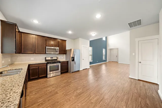 a view of kitchen with refrigerator stove microwave and cabinets