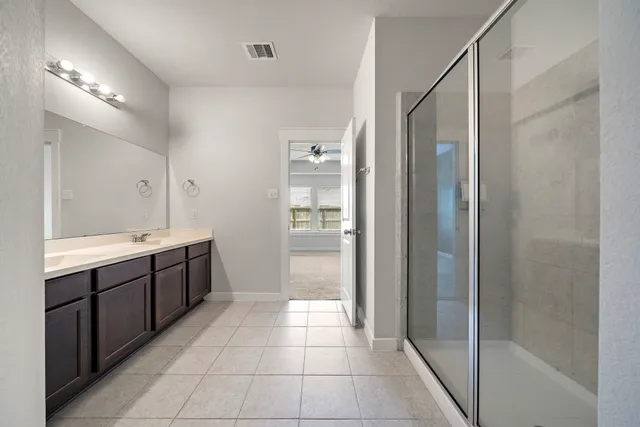 a bathroom with a double vanity sink toilet and shower