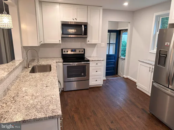 a kitchen with stainless steel appliances kitchen island granite countertop a stove a sink and a refrigerator