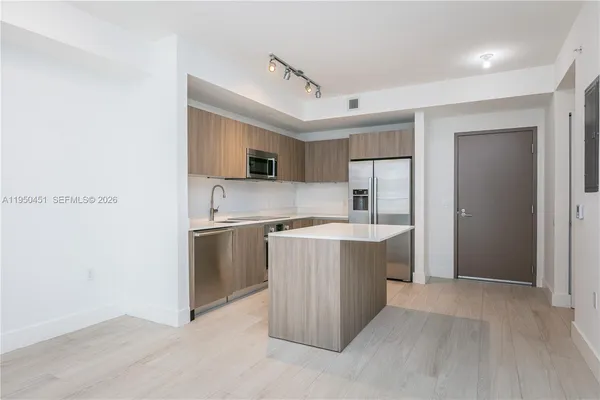 a large kitchen with a sink and dishwasher stove top oven