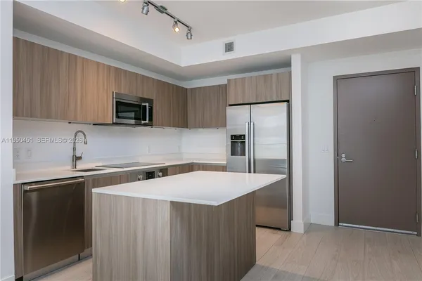 a kitchen with stainless steel appliances a refrigerator sink and microwave