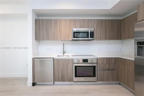 a kitchen with stainless steel appliances a stove microwave and sink