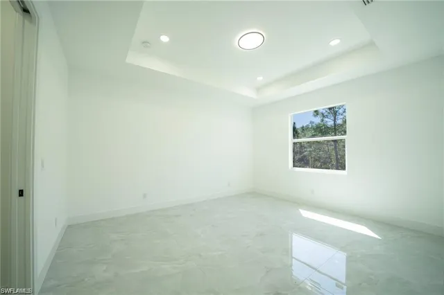 an empty room with a ceiling fan and a window