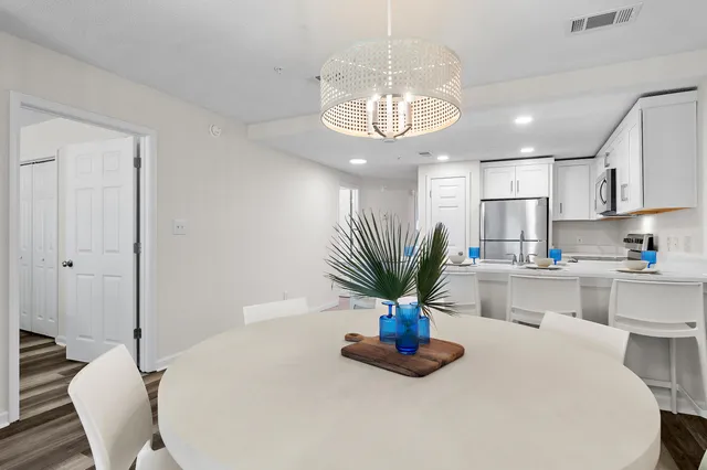 a dining room with wooden floor dining table and chandelier