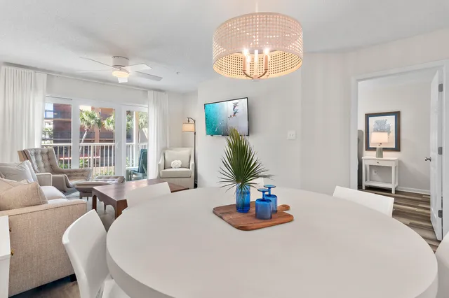 a dining room with wooden floor a chandelier a wooden table and chairs