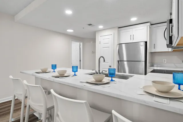 a kitchen with stainless steel appliances granite countertop a sink and a refrigerator