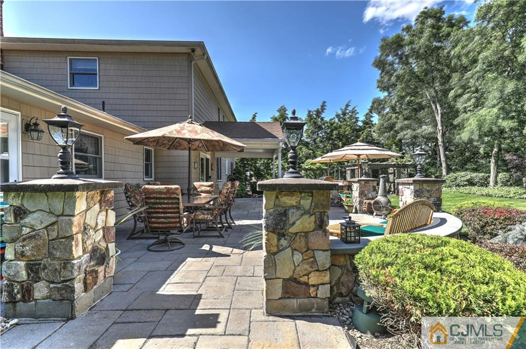 23 Winterberry Circle Piscataway, NJ 08854 - Photo 27 of 29 a view of a patio with table and chairs under an umbrella with a barbeque