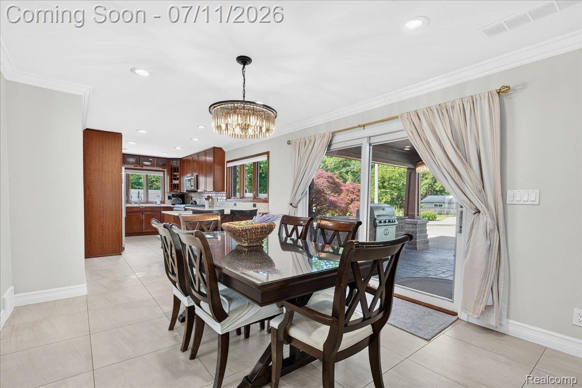 23750 East River Road Grosse Ile, MI 48138 - Photo 12 of 54 Dining area featuring a contemporary chandelier, tile flooring, and crown molding