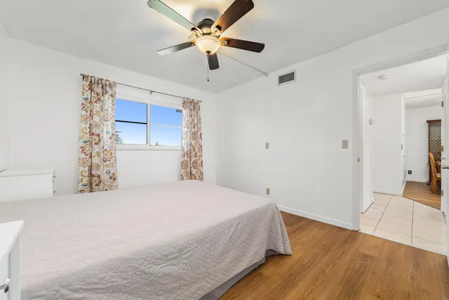 a bedroom with a bed and a ceiling fan