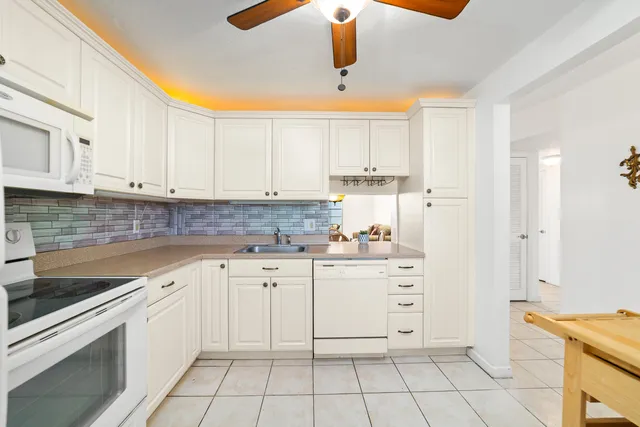 a kitchen with white cabinets appliances and a sink