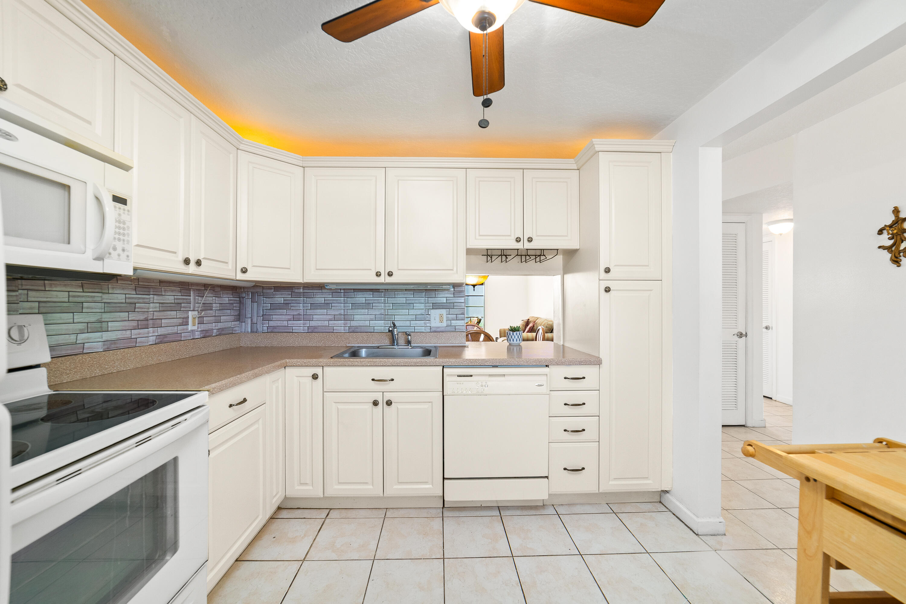 230 Northeast 26th Avenue, Unit 3020 Boynton Beach, FL 33435 - Photo 9 of 44 a kitchen with white cabinets appliances and a sink