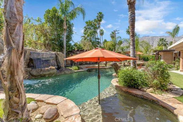 a backyard of a house with a swing table and chairs