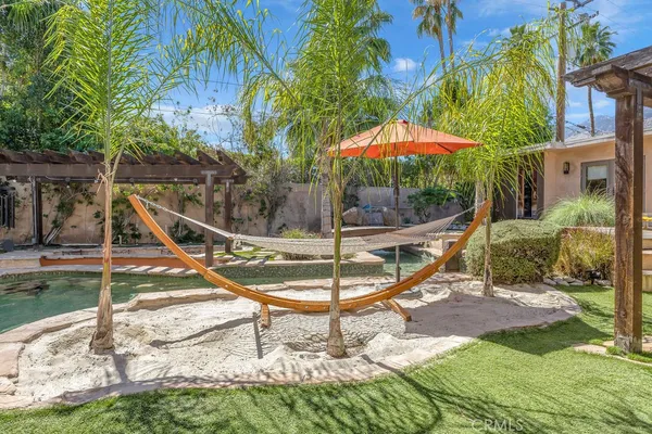 a patio with table and chairs and potted plants