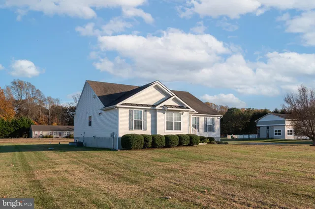 a open kitchen with stainless steel appliances kitchen island granite countertop a refrigerator oven a sink with a dining table and chairs with wooden floor