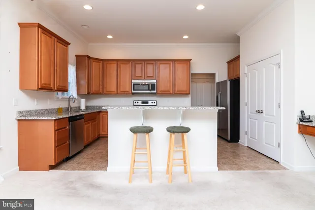 a kitchen with stainless steel appliances granite countertop a stove refrigerator sink and microwave