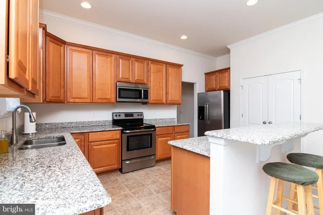 a kitchen with stainless steel appliances granite countertop a stove a refrigerator and a sink