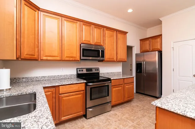a kitchen with stainless steel appliances granite countertop a sink stove and microwave