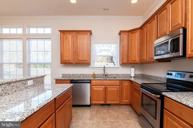 a kitchen with stainless steel appliances granite countertop a sink stove and microwave