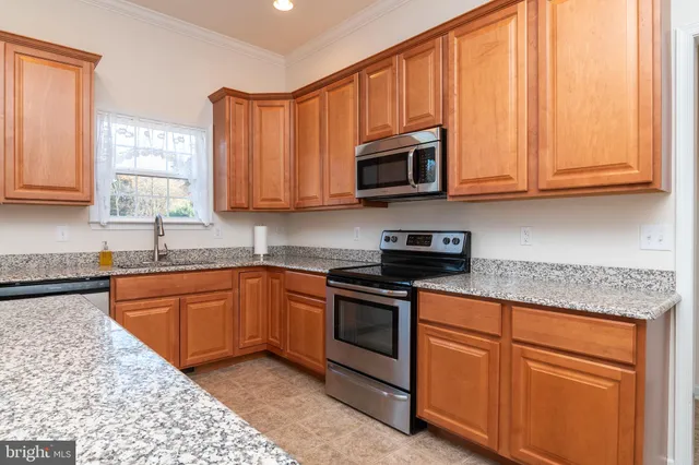 a kitchen with stainless steel appliances granite countertop a stove microwave and refrigerator
