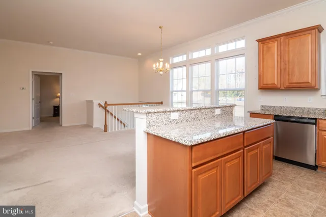 a kitchen with stainless steel appliances granite countertop a stove top oven a sink dishwasher a dining table and chairs with wooden floor