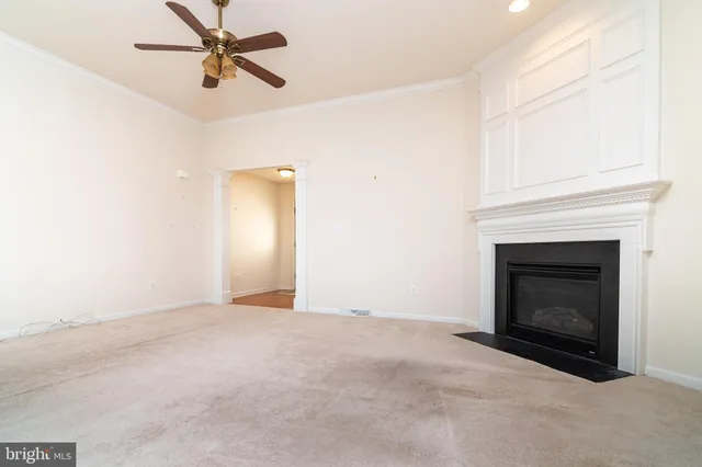 en empty room with windows and fireplace