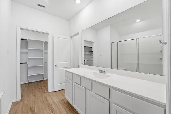 a spacious bathroom with a shower sink and a mirror