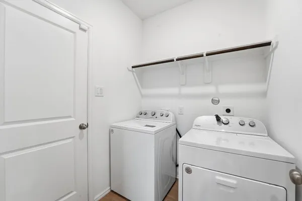 a view of washer and dryer with bathroom in the background