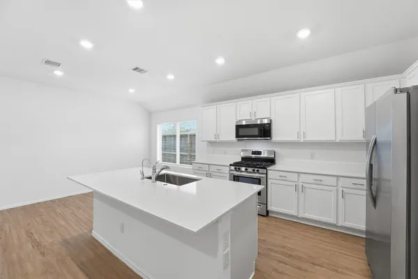 a kitchen view with stainless steel appliances a sink stove and refrigerator