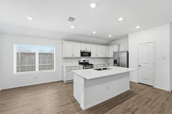 a kitchen with a stove a sink and a refrigerator