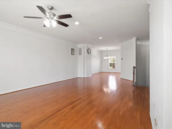 a view of a livingroom with a ceiling fan wooden floor and a ceiling fan