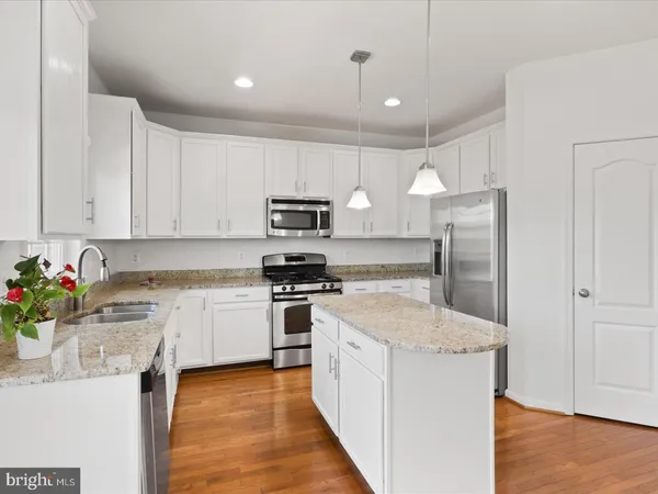 a kitchen with stainless steel appliances granite countertop a refrigerator sink and stove