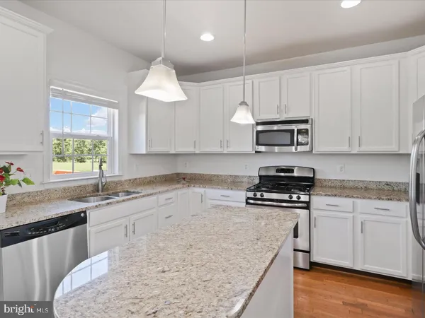a kitchen with stainless steel appliances granite countertop a sink stove and microwave