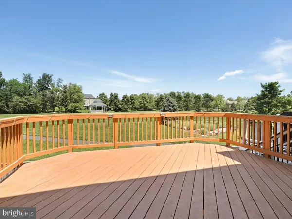 a view of deck with wooden floor and fence with a bench