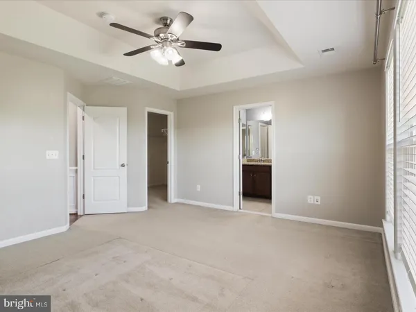 an empty room with a ceiling fan and a window
