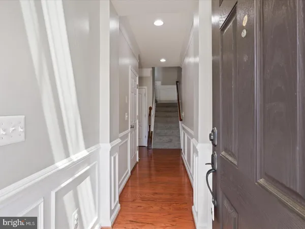 a view of a hallway with wooden floor and staircase