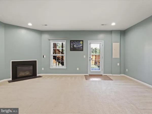 a view of an empty room with a fireplace and a window