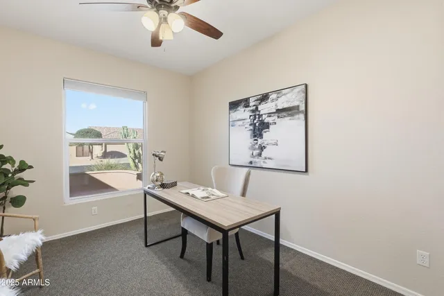 a view of a workspace with furniture and a window