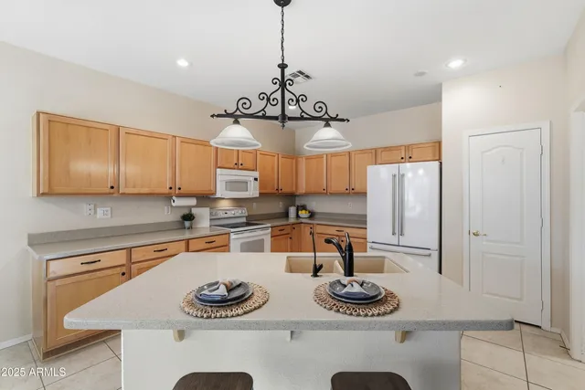 a kitchen with stainless steel appliances granite countertop a sink and a refrigerator