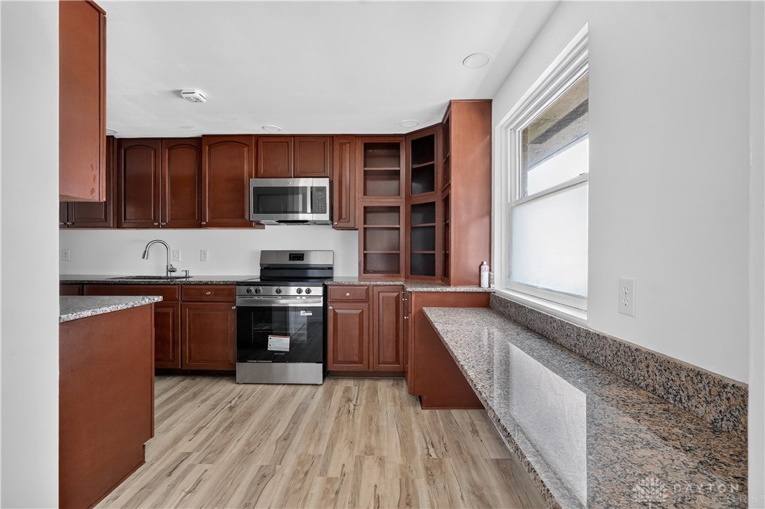 1243 Student Avenue Springfield, OH 45503 - Photo 11 of 38 Rich wood cabinetry paired with granite countertops defines this functional culinary space.