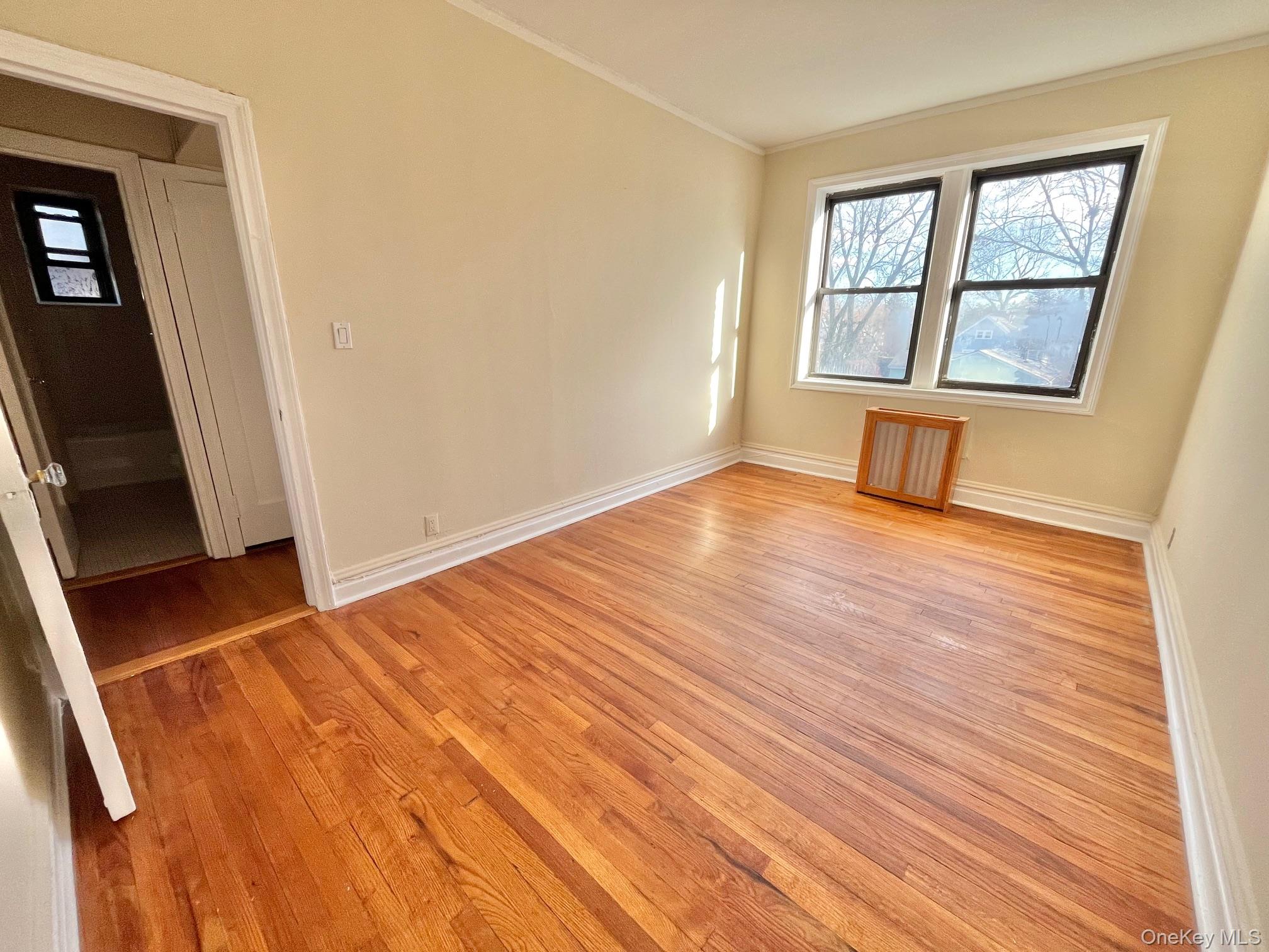 110 Stonelea Place, Unit 3B New Rochelle, NY 10801 - Photo 12 of 15 an empty room with wooden floor and windows