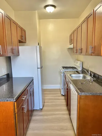 a kitchen with stainless steel appliances granite countertop a sink a stove and a refrigerator