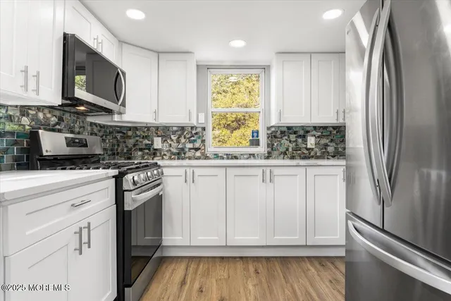 a kitchen with stainless steel appliances granite countertop a refrigerator sink and microwave