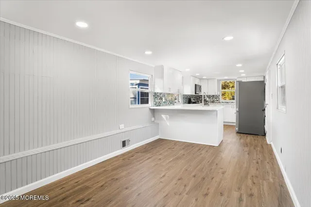 a kitchen with stainless steel appliances a refrigerator sink and white cabinets
