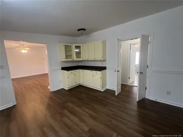 an empty room with wooden floor and cabinet