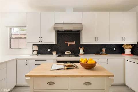 a kitchen with stainless steel appliances granite countertop white cabinets and white stove